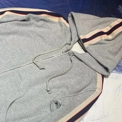 Grey zip hoodie with striped trim around the hood and sleeves