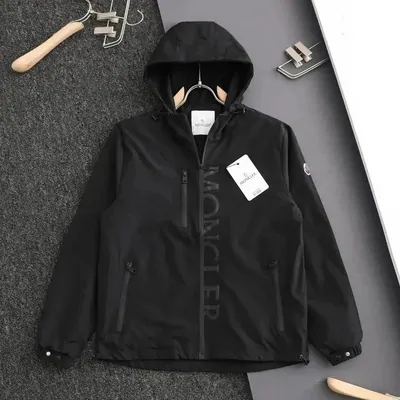 A black hooded zip jacket laid flat on grey carpet with the tag still on