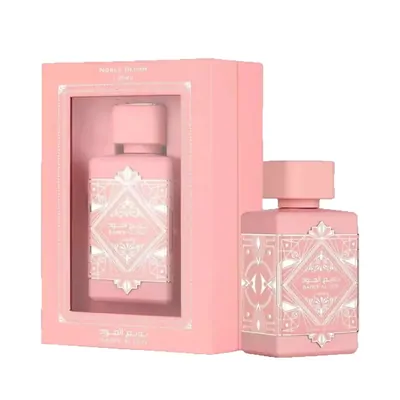 A pink perfume bottle standing beside its matching pink window box